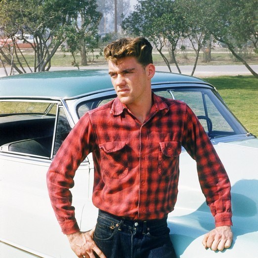 Race car driver Dave MacDonald near his 1953 green Cadillac